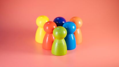 Coloured wooden figures on orange background