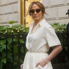 Jennifer Lopez wearing a shirt dress and cat-eye sunglasses in Paris.