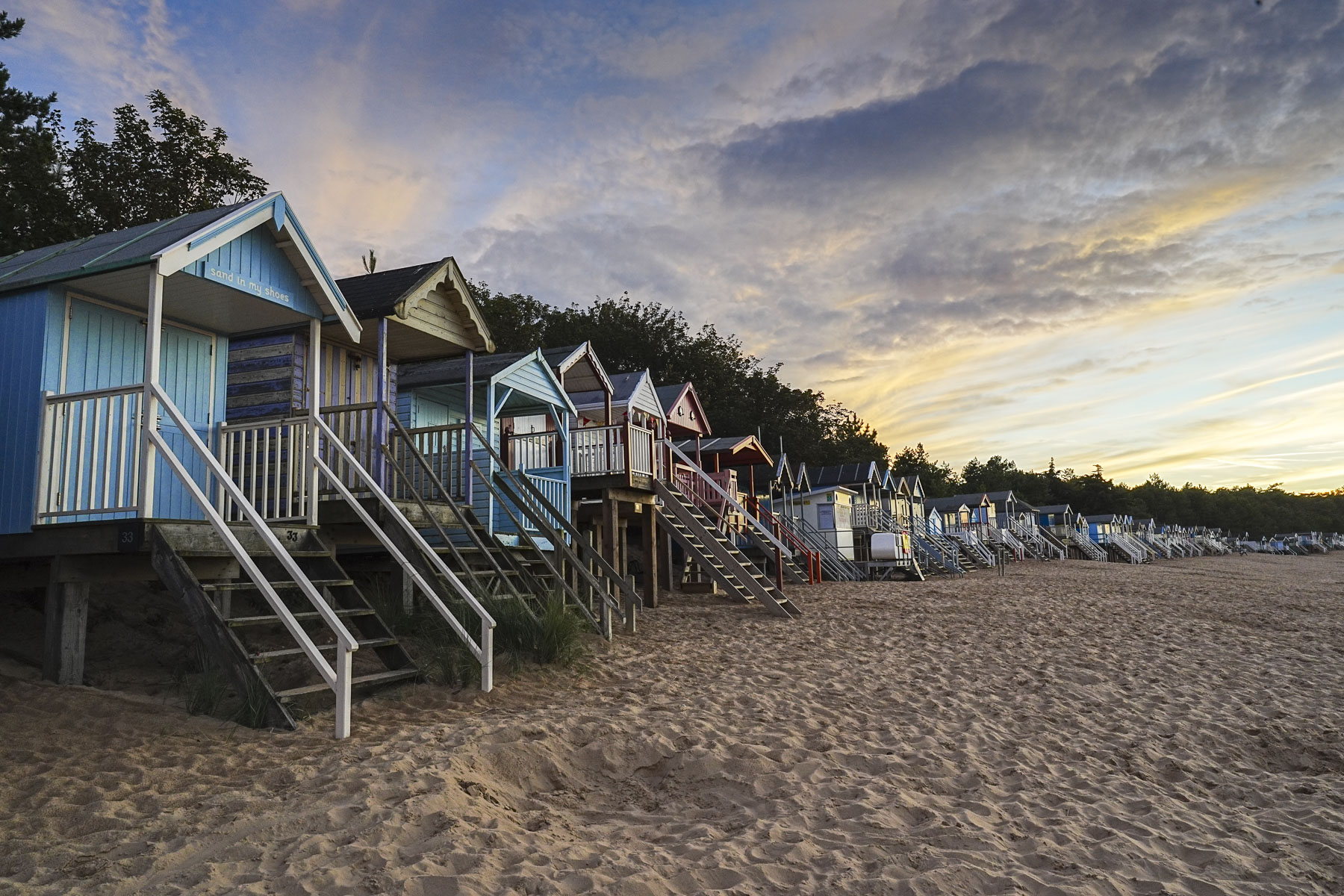 Beach huts on a sandy beach at golden hour captured with the Sony A7C II full-frame mirrorless camera