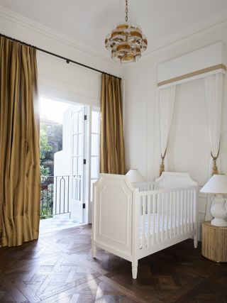 Elegant neutral nursery with gold curtains and bed canopy