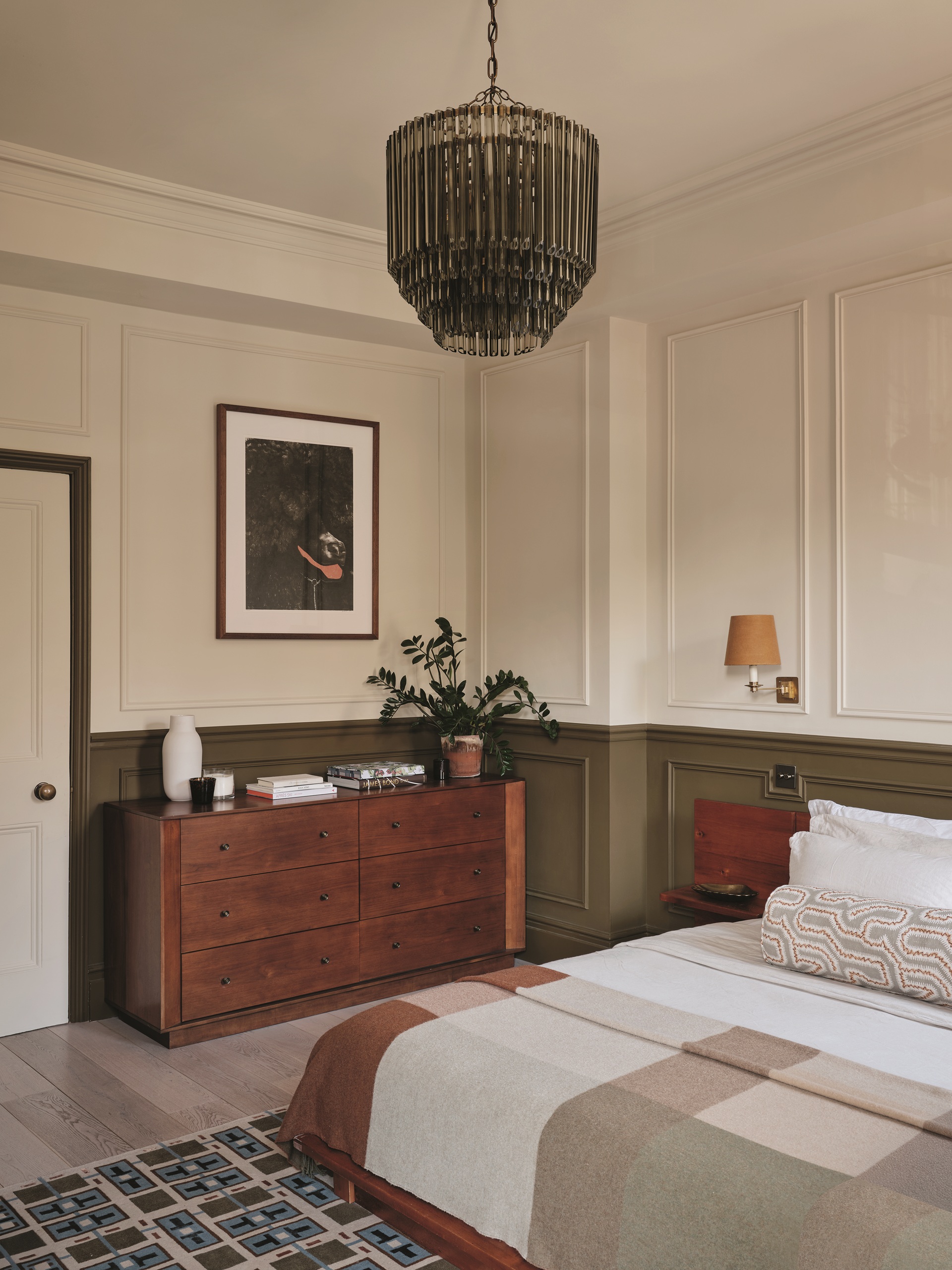 a bedroom with green and white walls, and wood cabinetry
