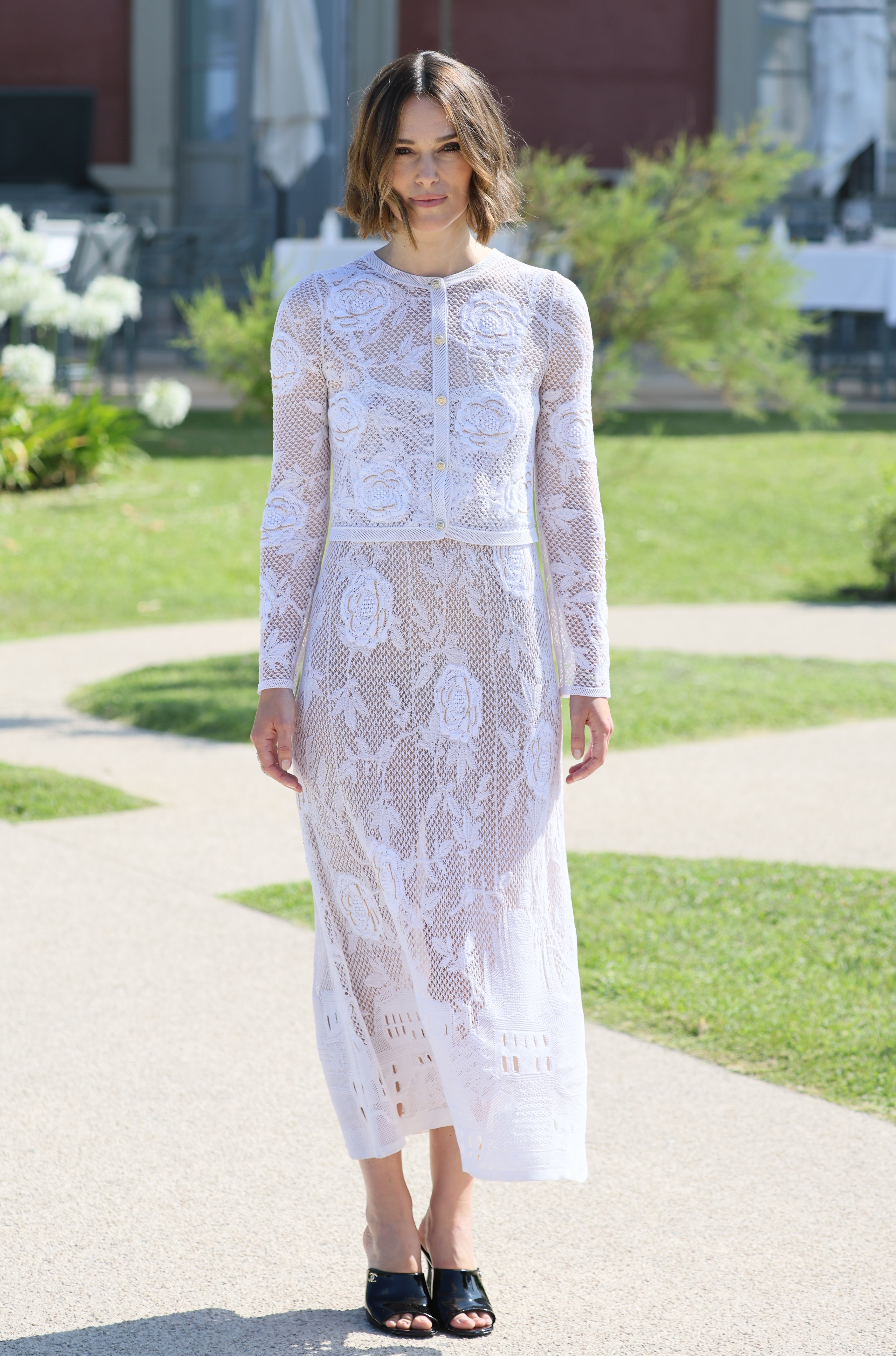 Keira Knightley wears a white skirt and black sandals