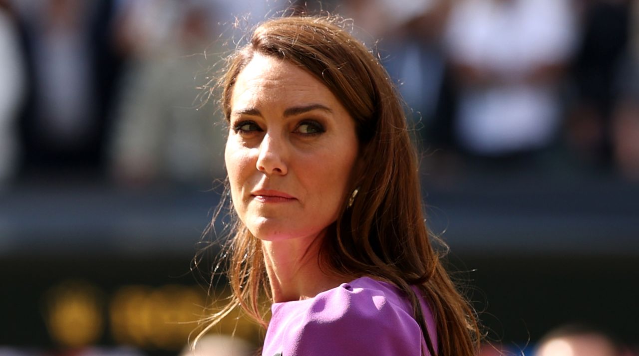 Kate Middleton has long brown hair and turns around at Wimbledon in 2024, where she is wearing a purple dress