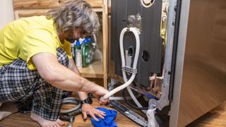 Man checking dishwasher hose