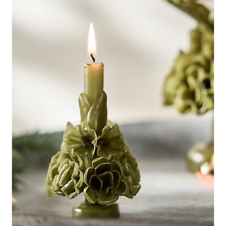 olive green taper candle standin with a carved floral design