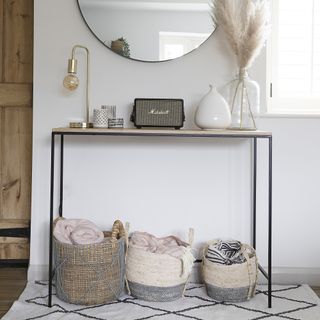Minimalist console table in a hallway with white walls and decorative accessories on show.