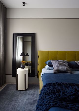 a modern bedroom with yellow headboard