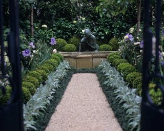 garden path leading to statue with repeated planting of buxus, stachy and hydrangeas on both sides