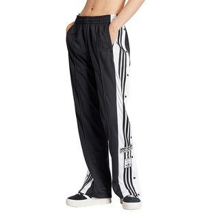 half shot of model wearing black Adidas track pants