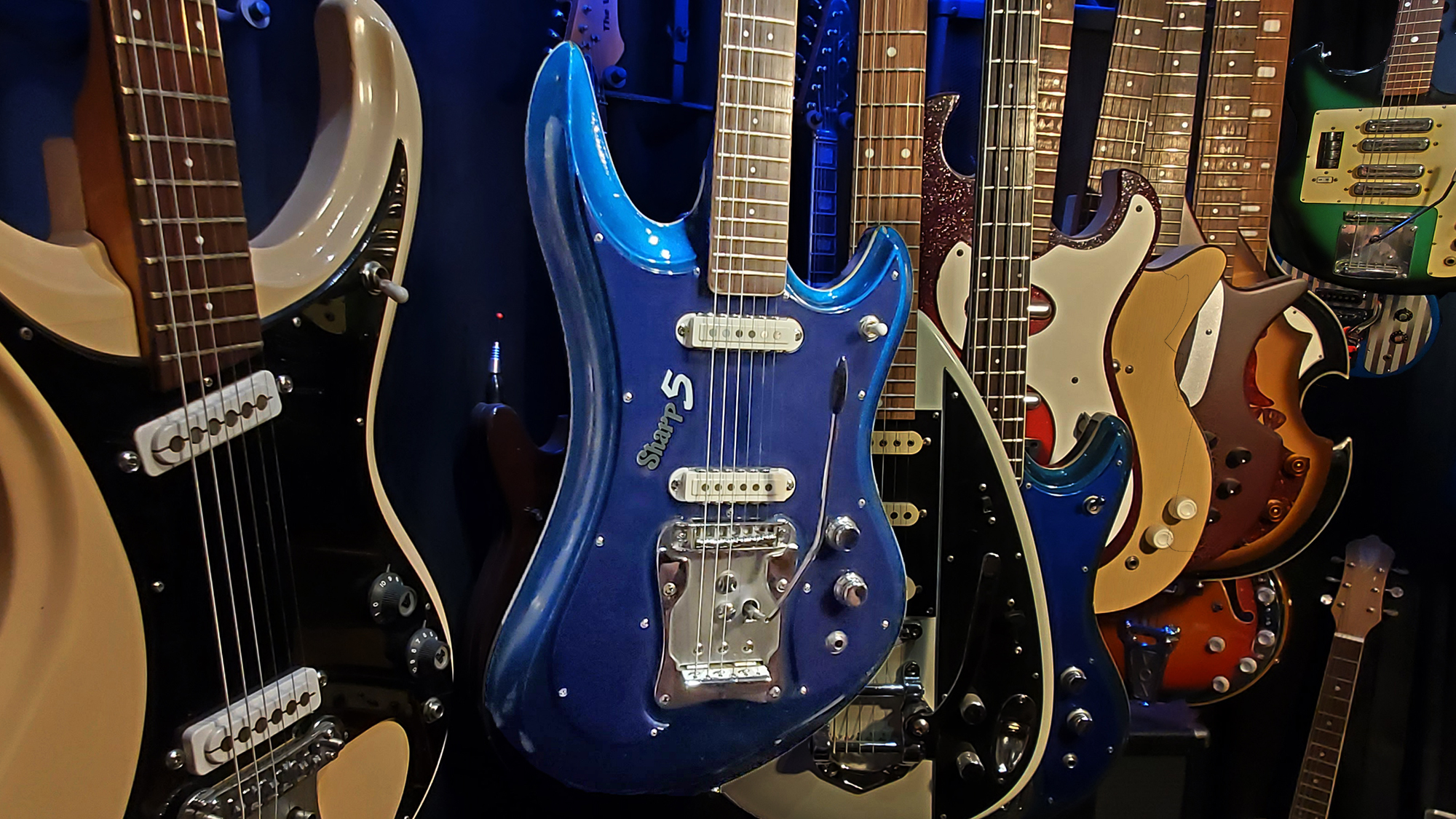 A collection of 1960s Japanese guitars, with a blue Guyatone LG 350-T "Sharp 5" at the center