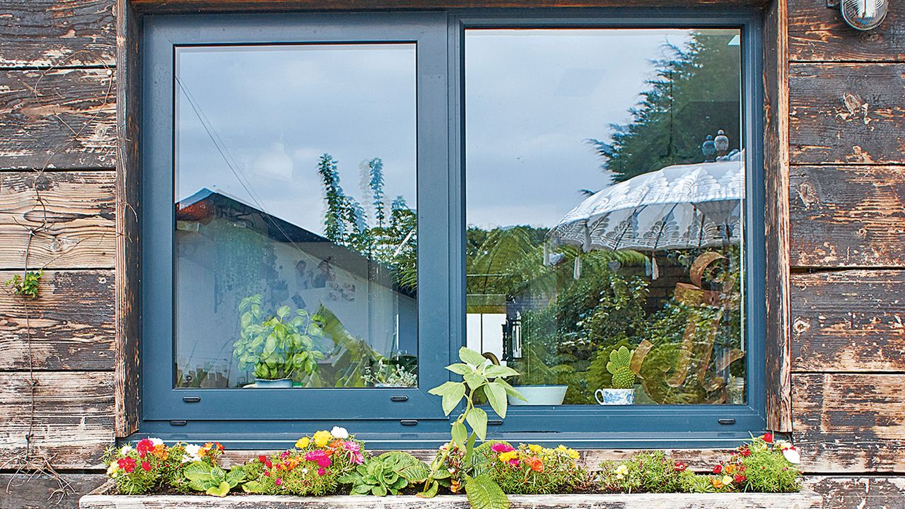 graphite painted upvc window frames with window box on wooden exterior of house