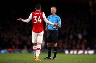 Granit Xhaka speaking to referee Martin Atkinson before his substitution