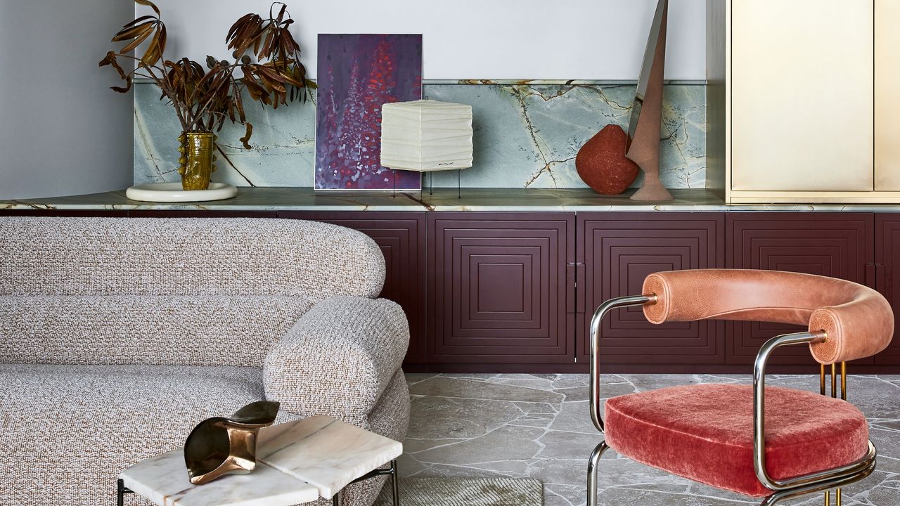 a cinema room with a purple sideboard red chair and brass cabinet with green marble