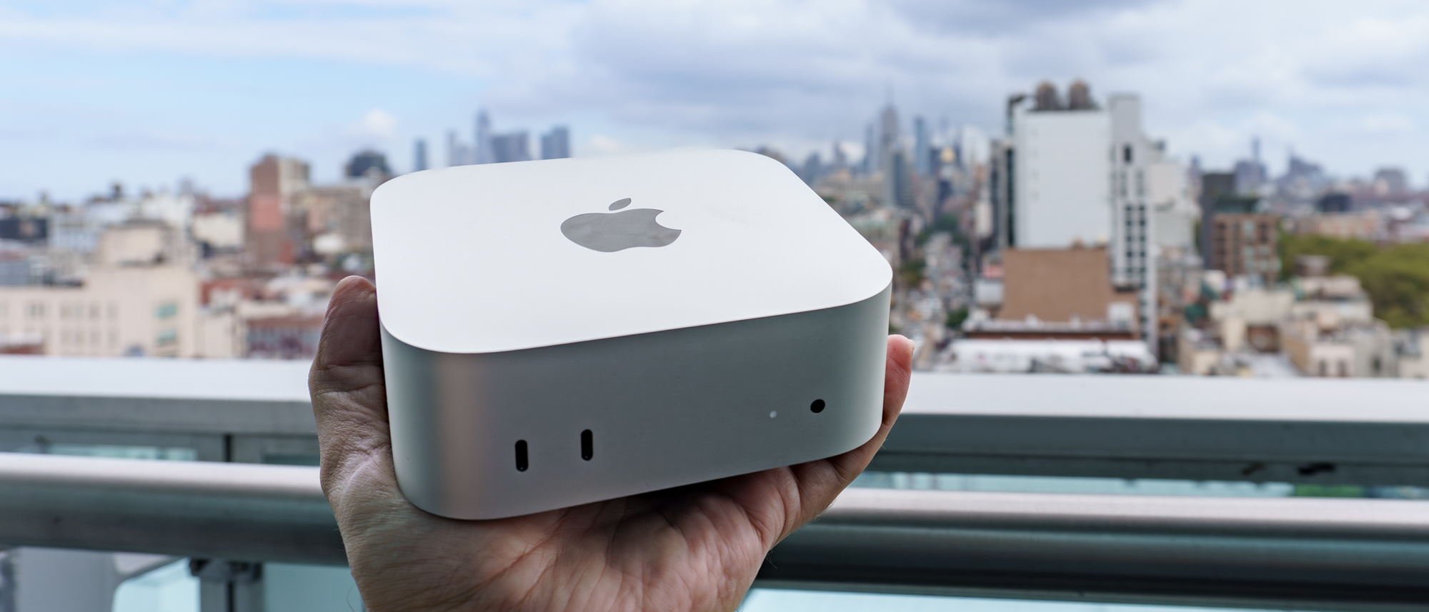 A person holding a Mac mini with M6 in hand