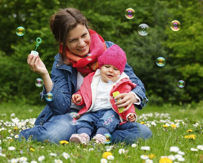 A mom and baby play in the park