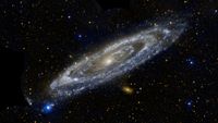 A beautiful white and blue spiral galaxy is seen slightly edge-on with a vast black section of space behind it. There are glowing dots and orbs all across the darkness.