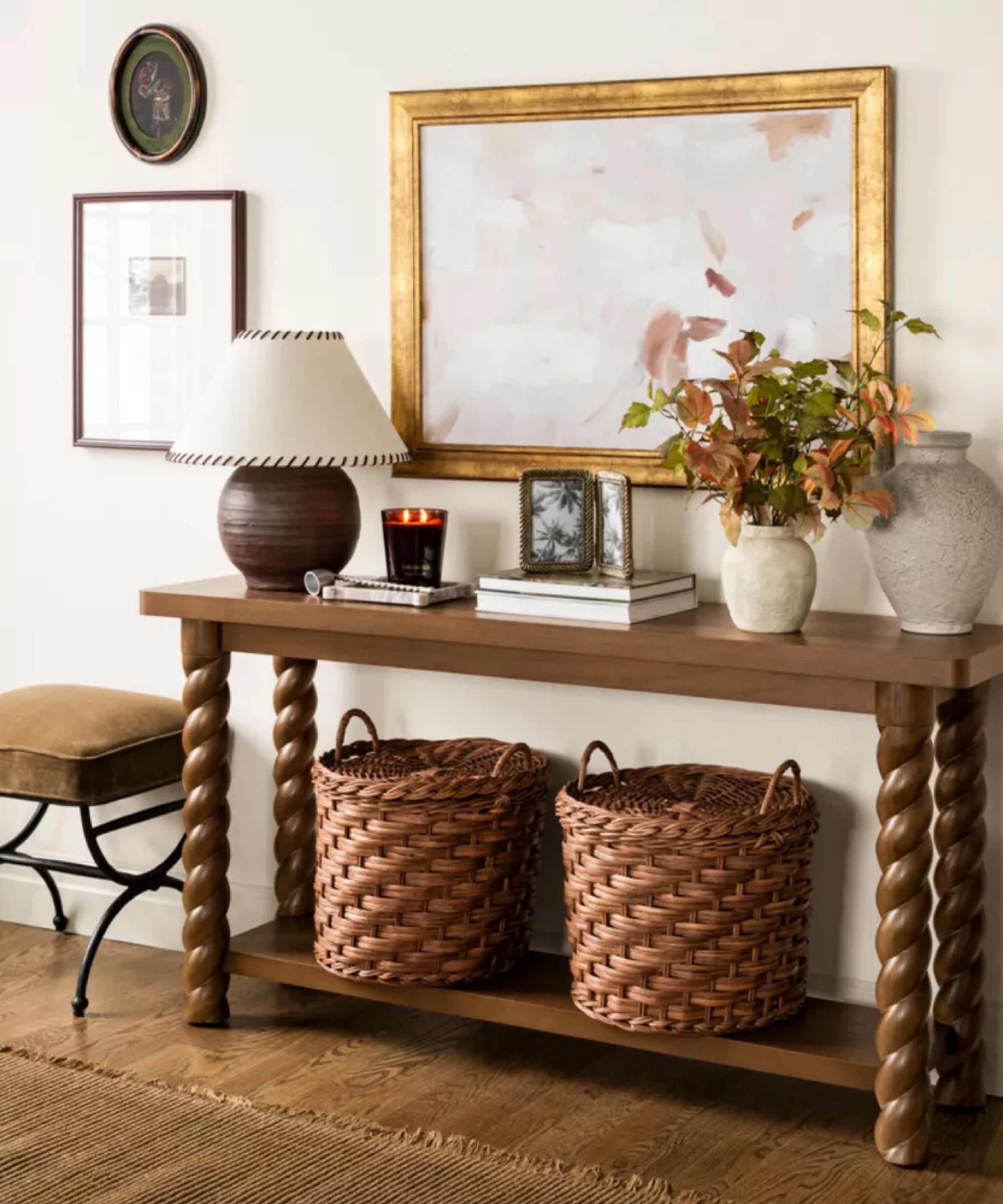 entryway table styled for the shea mcgee x target collaboration with a dark walnut twisted wooden console table styled with a lamp, baskets, and a vase