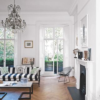 white walls with wooden flooring and chandelier