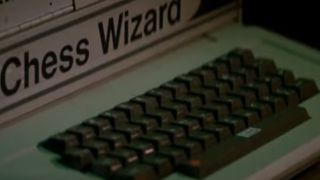 An old computer with a keyboard and a sticker that says "Chess Wizard" in The Thing