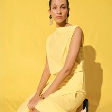 Woman wearing light yellow Selfridges dress with yellow background