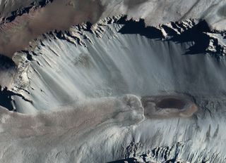 A satellite image of Don Juan Pond, showing dark streaks on the surrounding hillsides that look eerily like the recurring slope lineae seen on Mars.