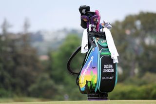 Dustin Johnson's bag stands next to the green