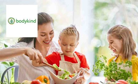 bodykind logo placed over a mother making salad with her kids