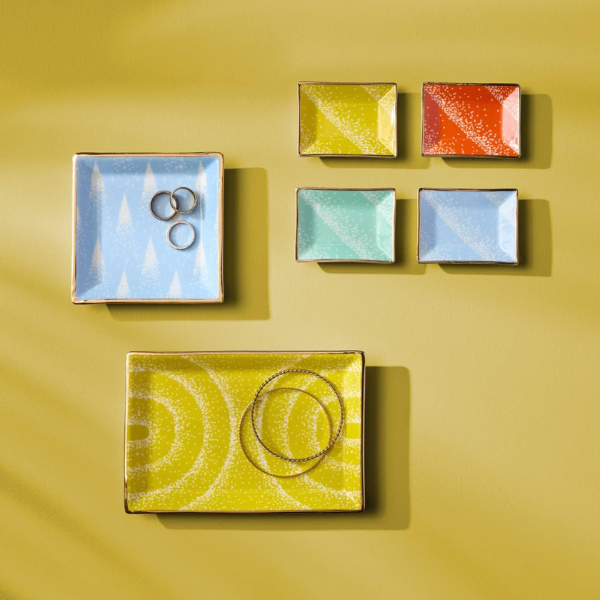 jonathan adler set of colored trinket trays on a yellow background