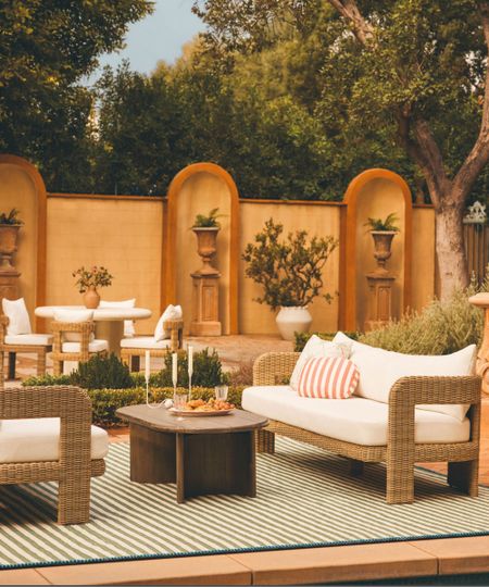 Outdoor seating area with rattan sofas, outdoor rug and coffee table