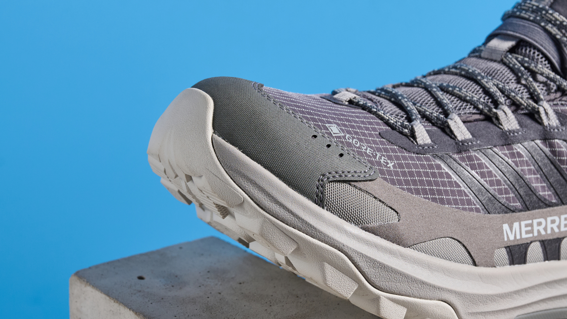 A photo of the Merrell Moab Speed 2 boots against a blue background