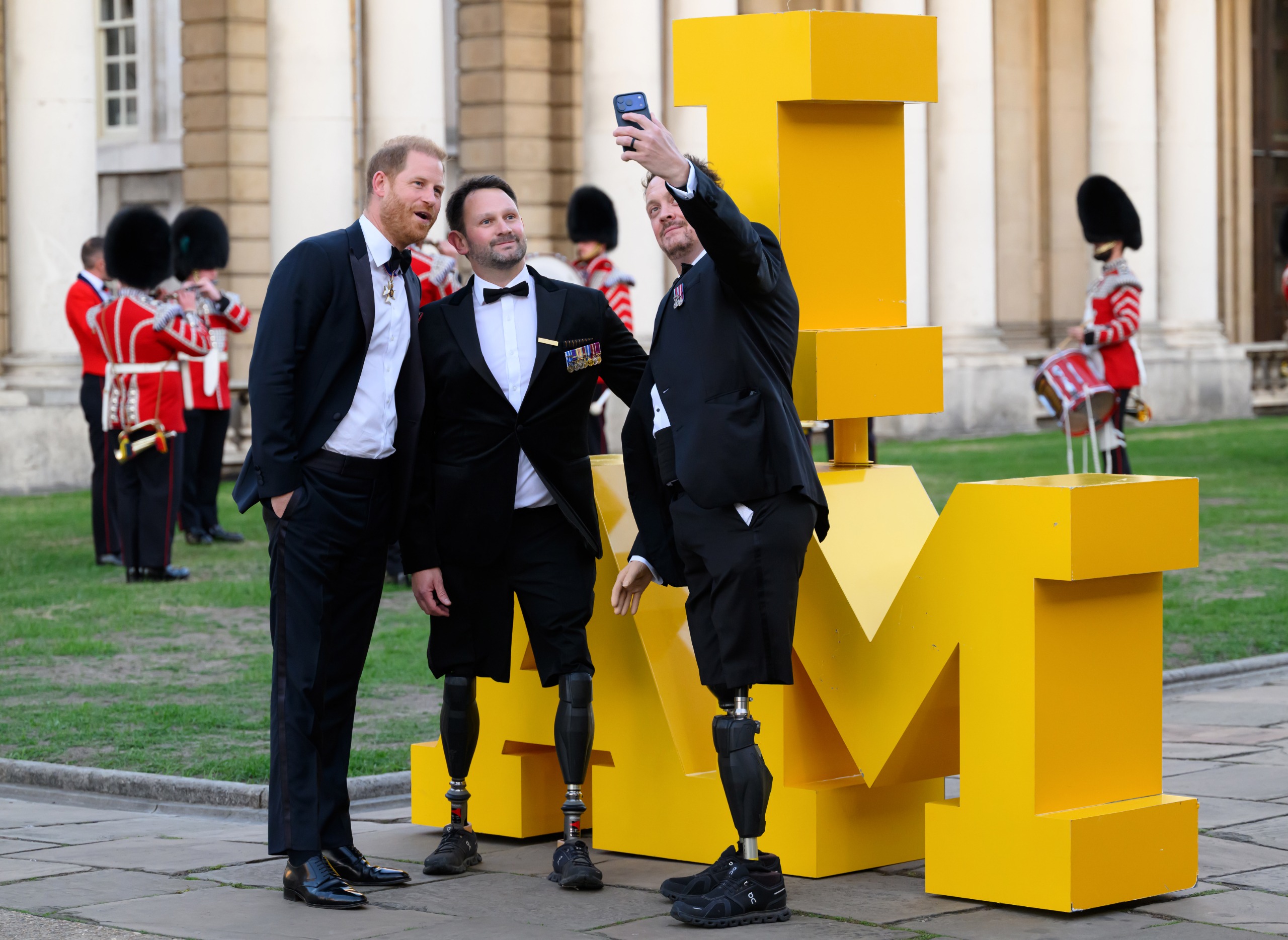 Prince Harry snaps a selfie with two men at the Invictus Spirit Awards