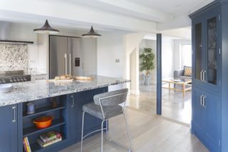 a garage converted into a blue and white modern kitchen and living space by Stephen Graver