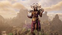 A mage wearing purple robes and a bone headdress stands on a mountain. A ruined castle crouches in the background.