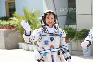China's first female astronaut Liu Wang waves to supporters while clad in a spacesuit just before boarding the Shenzhou 9 space capsule for a successful June 19, 2012 launch from the Jiuquan Satellite Launch Center.