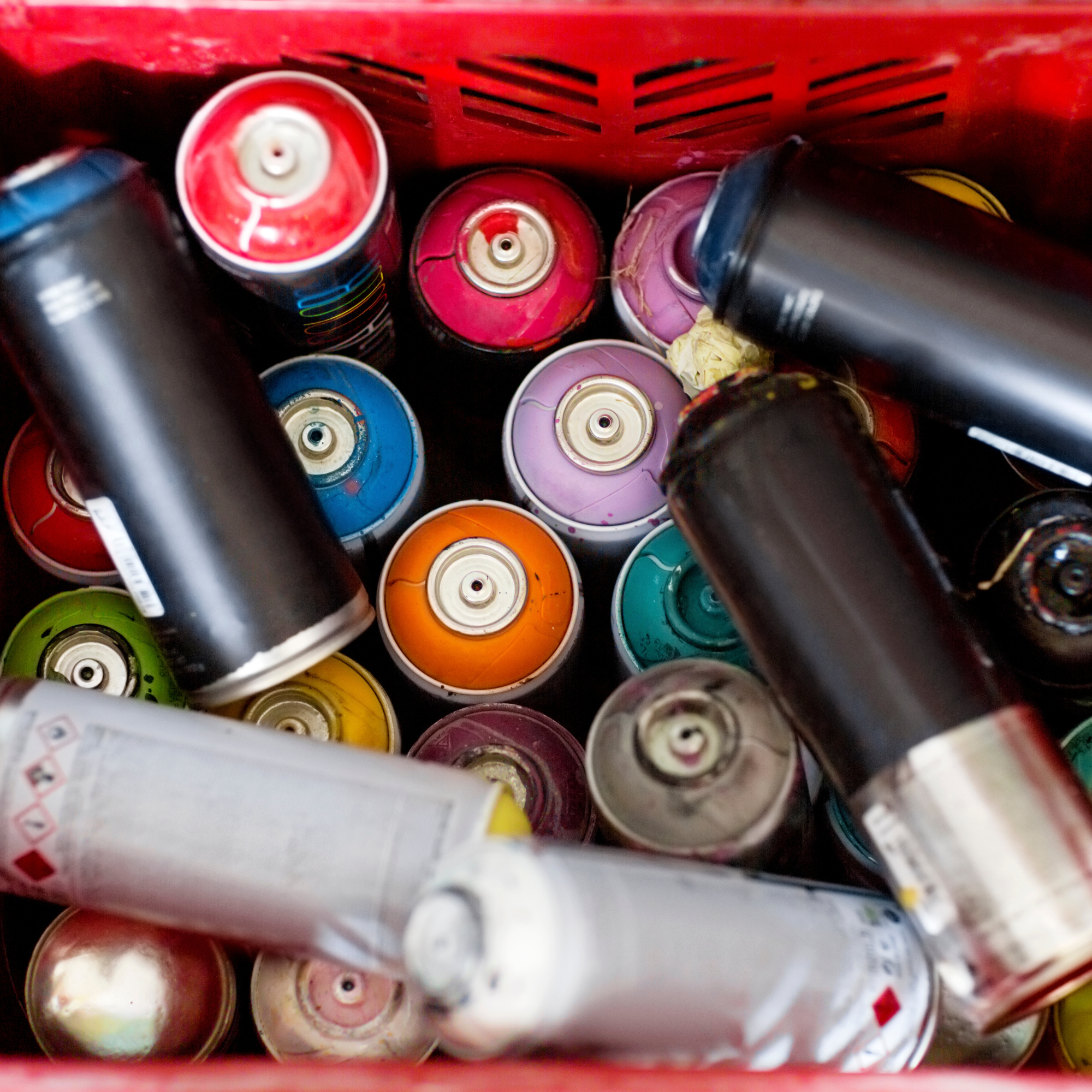 Spray paint cans in plastic crate