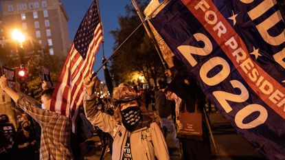 People hold signs and dance at a Black Lives Matter rally outside the White House