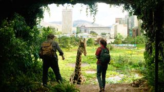 A shot of Joel and Elie from The Last of Us HBO show looking at a giraffe