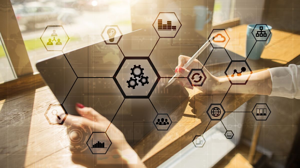 Two hands holding a tablet and stylus. Superimposed is a visualisation of a network of hexagonal nodes