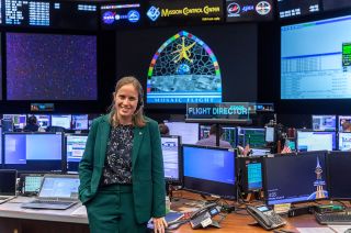 Fiona Turett, NASA's 100th flight director, poses for a photo at her console in the Mission Control Center at Johnson Space Center in Houston, Texas on Monday, Jan. 10, 2022.