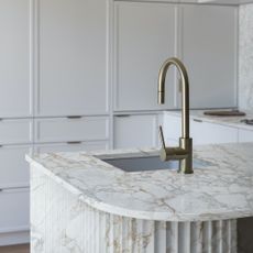 marble worktop island with fluted sides and steel tap