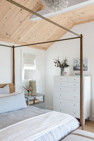 white bedroom with poster bed and wood ceiling