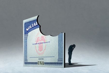 A male senior stands in the shadow of a Social Security card with bite missing.