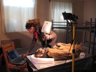 A student participating in the field school trained to use a portable multispectral imaging system taking some measurements on mummy Locus 9, which is described in the new study.