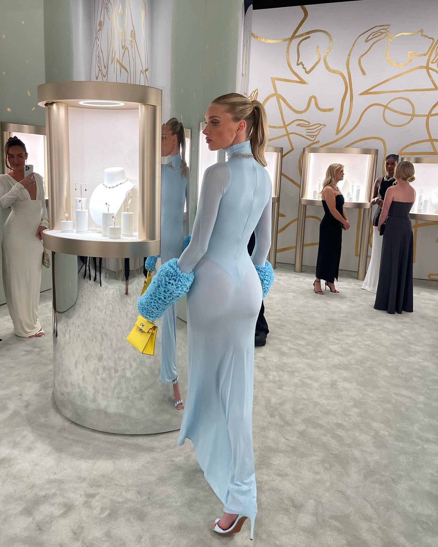 Elsa Hosk is photographed from behind wearing a light blue maxi dress with visible thong underwear