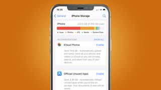 Een iPhone tegen een oranje achtergrond met op het scherm de 'Offload Unused Apps'-feature