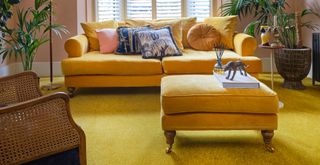 Vibrant living room with yellow carpet and yellow sofa and footstool to demonstrate the bold new flooring trend 2023 for colored carpets