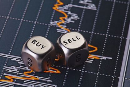 two silver dice with words "buy" and "sell" sitting on top of stock chart