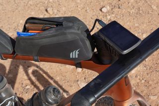 Tailfin Top Tube Pack mounted on a gravel bike with the zip open