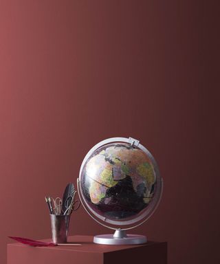 dark red wall with globe on table