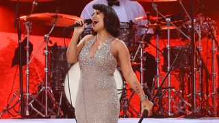 RAYE performs onstage in a glittery silver dress ahead of her performance at the &#039;American Music Awards&#039; 2024